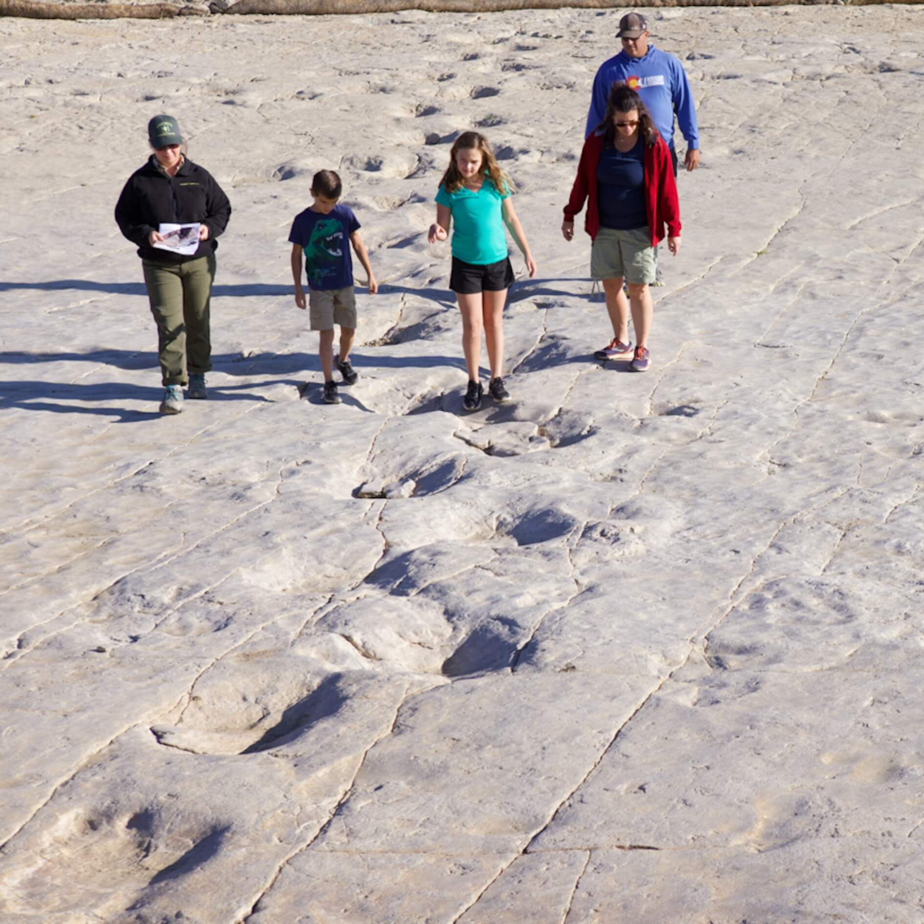Family hiking along dinosaur tracks